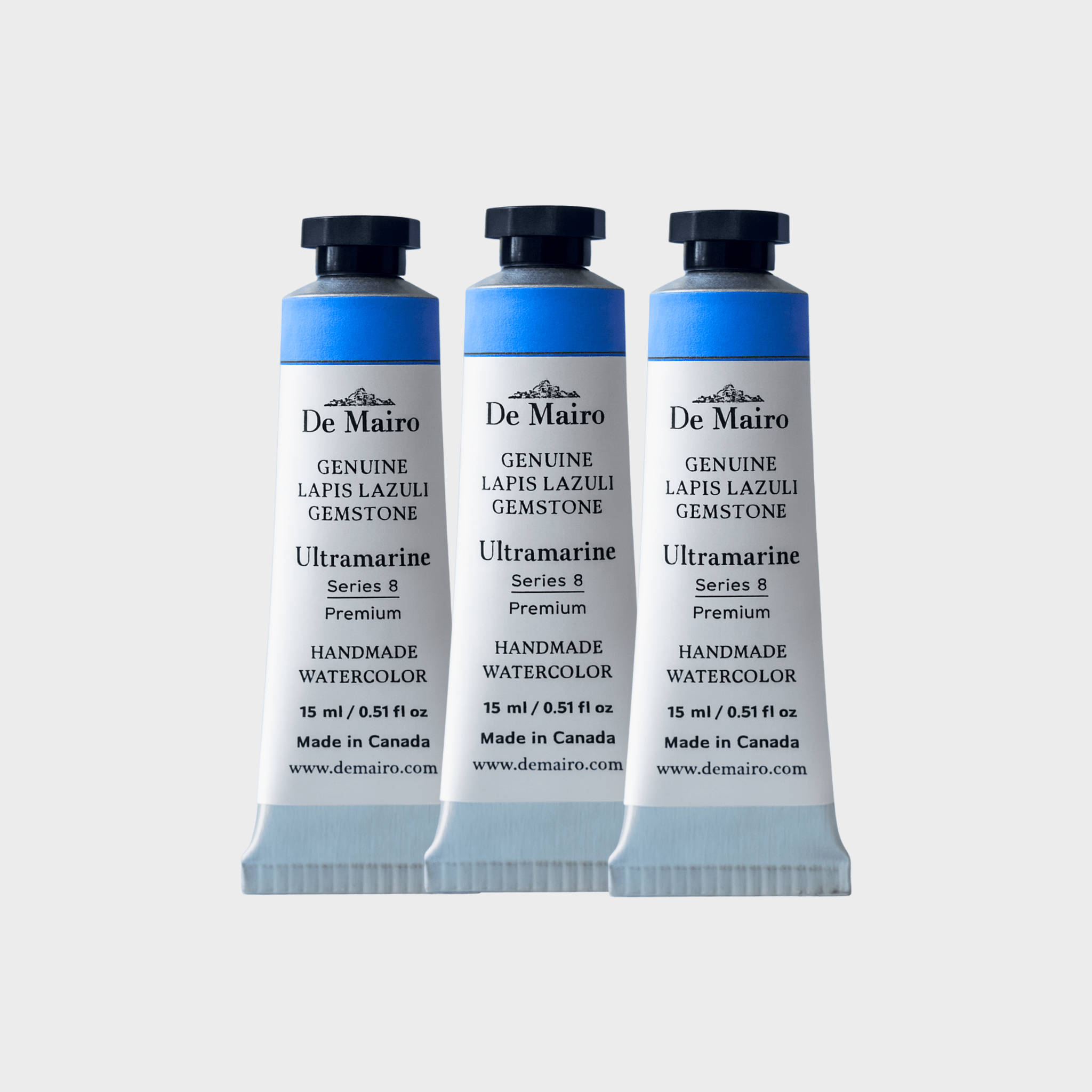 Three De Mairo watercolor paint tubes on a light gray background