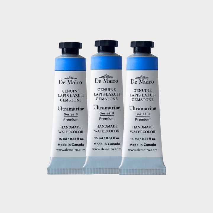 Three De Mairo watercolor paint tubes on a light gray background
