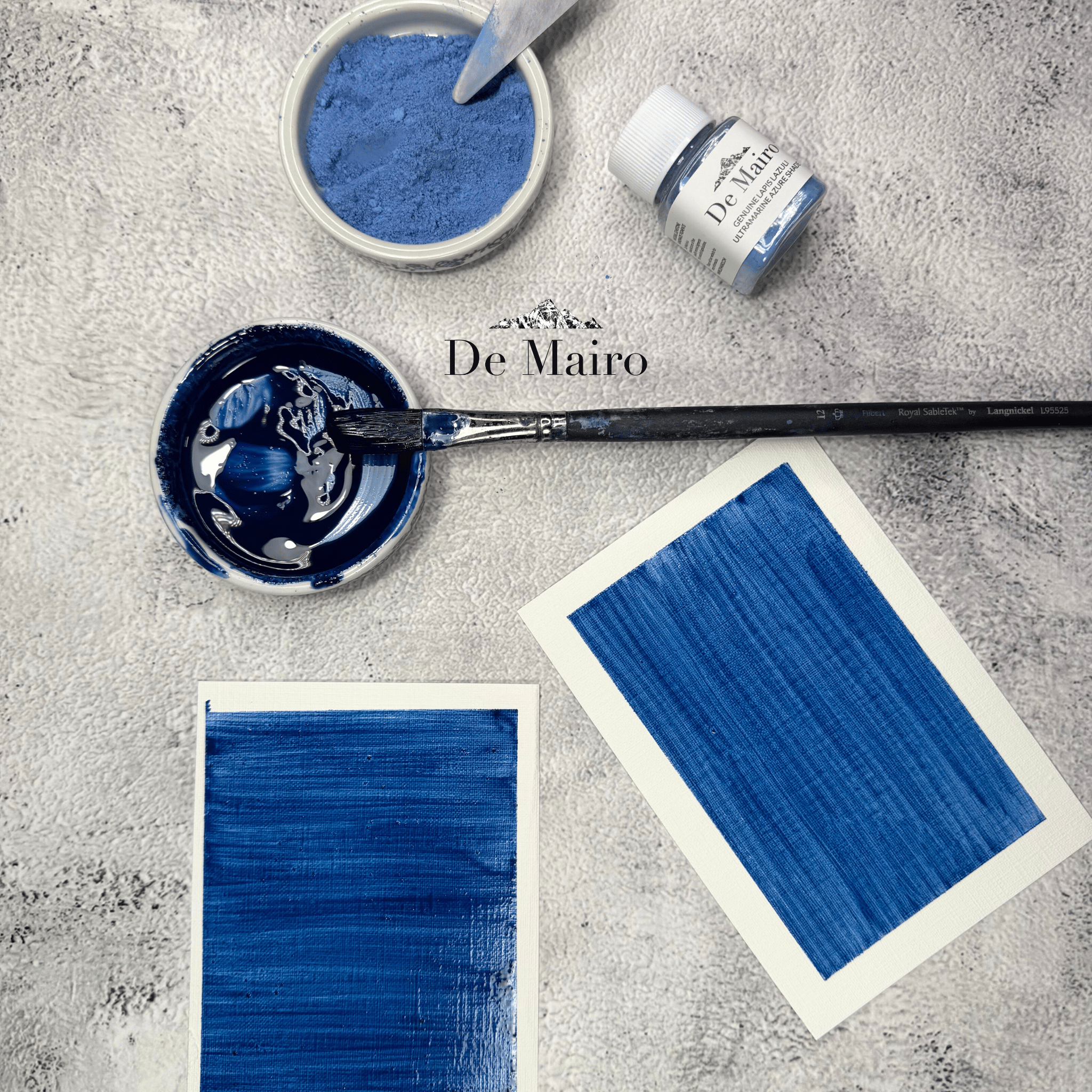 Ultramarine Azure Shade Pigment oil swatches near a mixed azure pigment in a dish with paint brsush and a dish with dry pigment with a palette aside a jar of de mairo azure shade