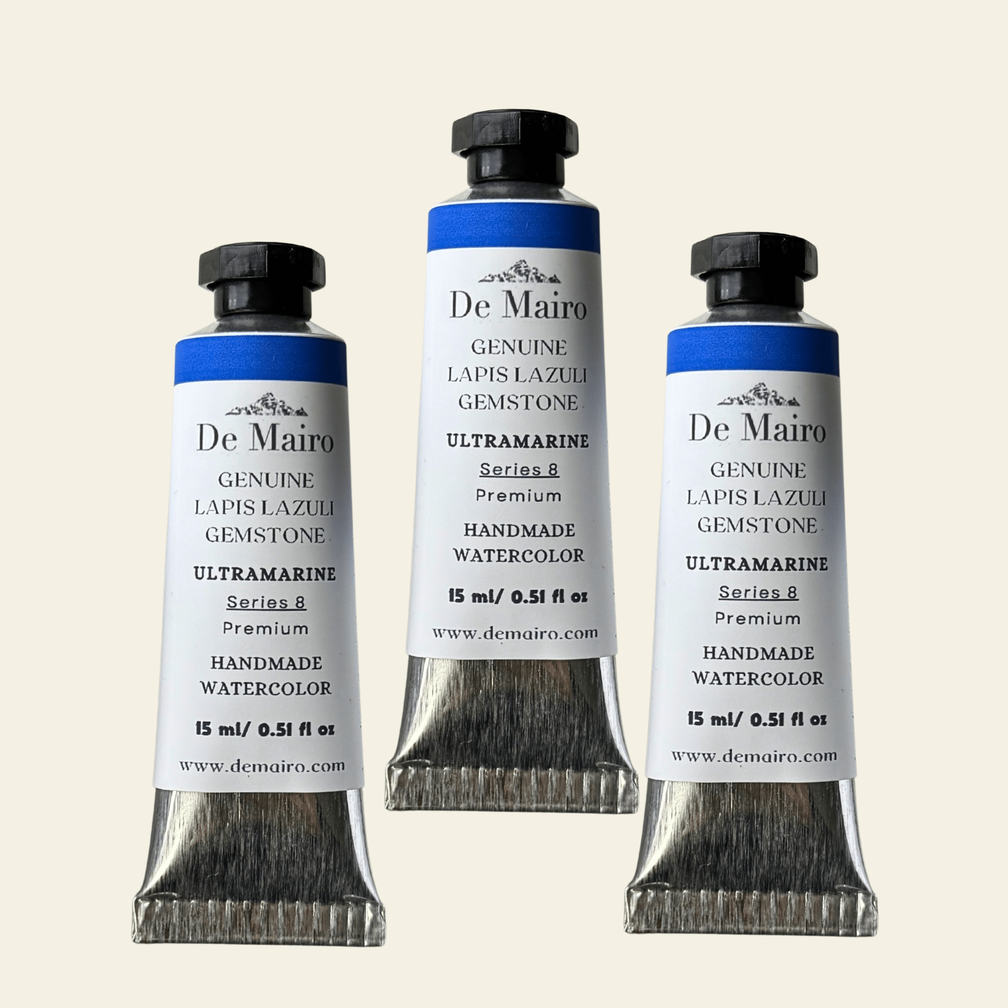 Three tubes of De Mairo watercolor paint on a white background