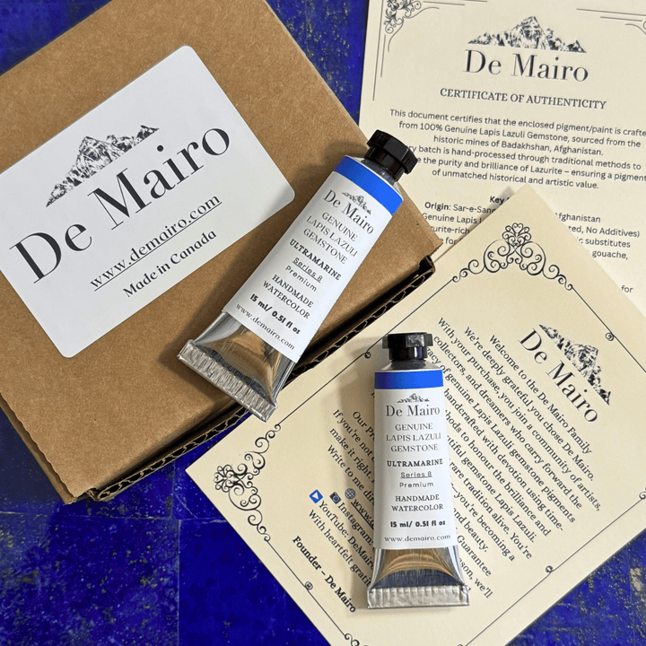 De Mairo watercolor paint tubes with packaging and certificate on a blue surface