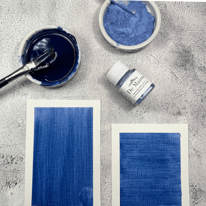Ultramarine Ash Shade oil medium swatches near a pigment jar, a dish with powdered pigment and another dish with blended pigment with paint brush in it 