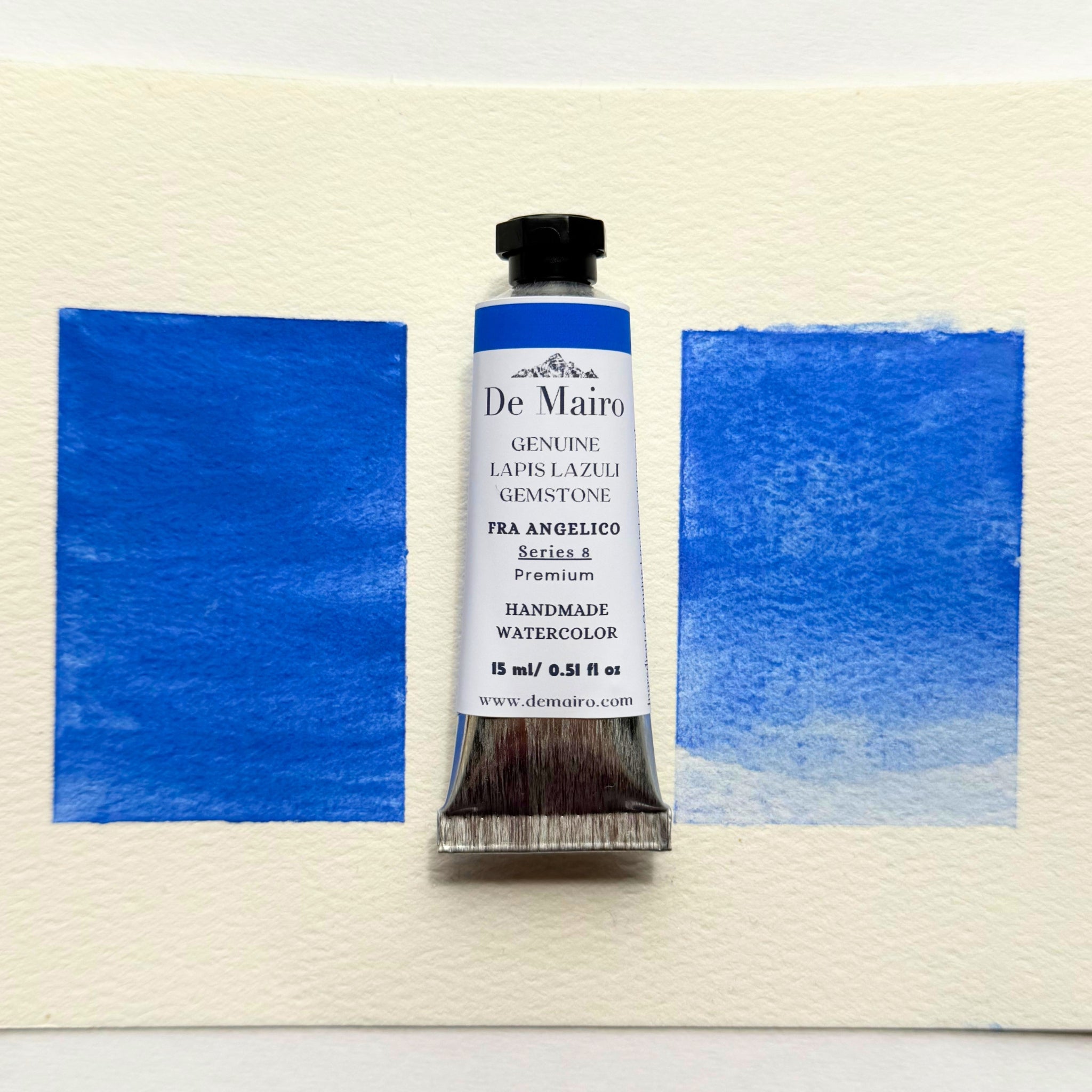 Tube of De Mairo watercolor paint with blue swatches on a watercolor paper