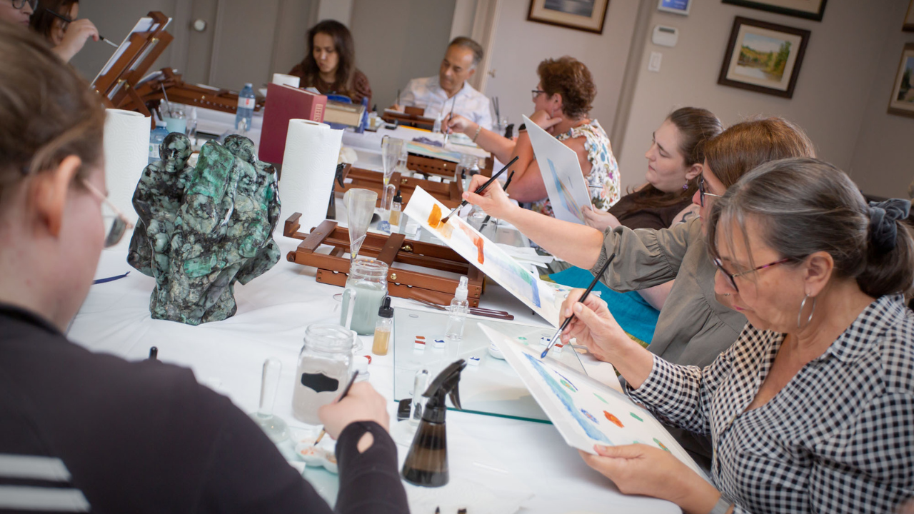 Art class in progress with students at a table using different gemstone pigments