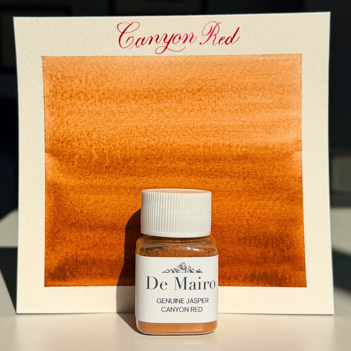 Canyon Red jasper pigment swatch in warm orange with the De Mairo bottle