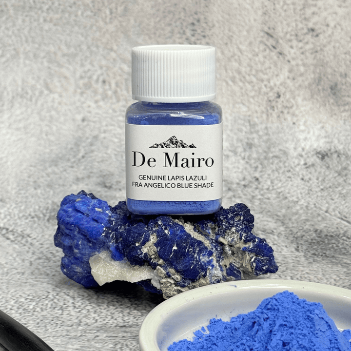 Jar of De Mairo genuine lapis lazuli Fra Angelico blue pigment resting on a raw lapis stone beside a dish of blue powder