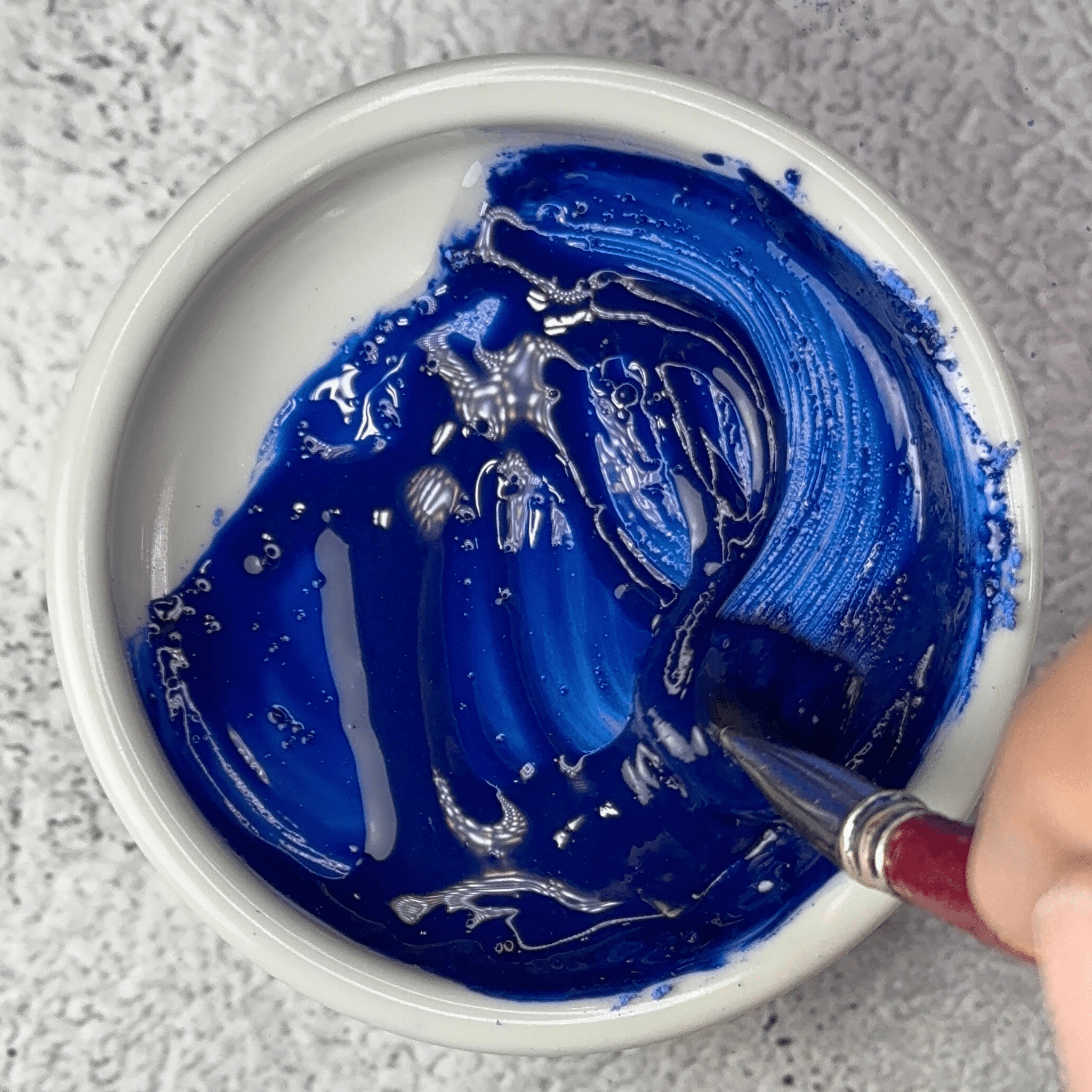 Genuine lapis lazuli Fra Angelico pigment mixed into glossy blue oil paint in a dish