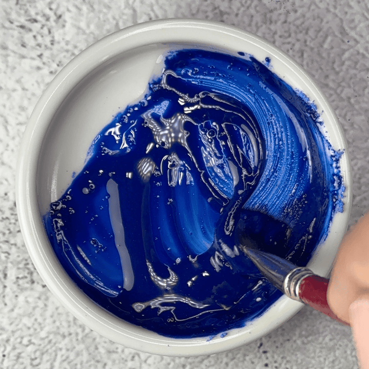 Genuine lapis lazuli Fra Angelico pigment mixed into glossy blue oil paint in a dish