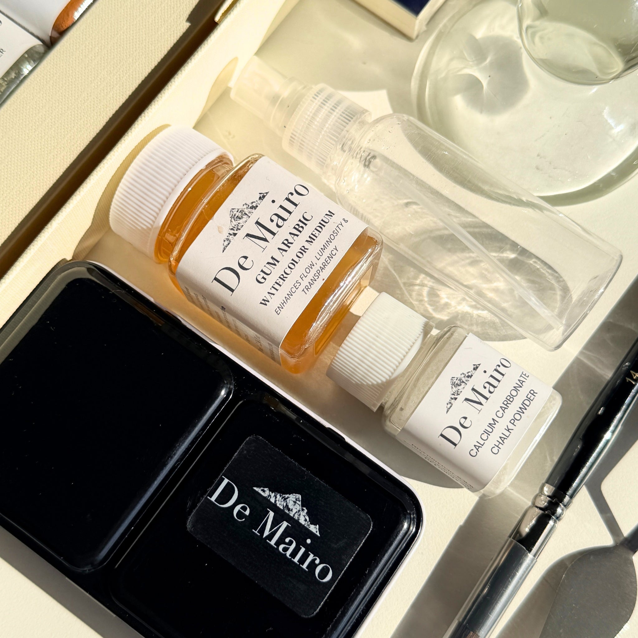 De Mairo gum arabic and calcium carbonate mediums beside the watercolour tin